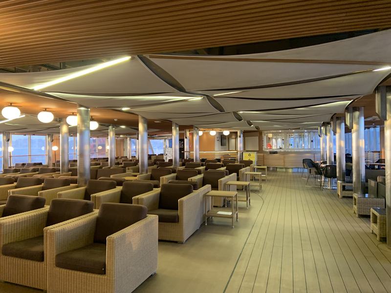 Eleven hours in a chair — The Top Deck Lounge: rows of wicker armchairs under white sail-shaped canopies,