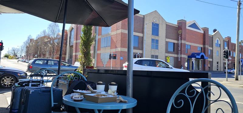 A gorge at the end of the street β A corner table under an umbrella outside The Flying Sparrow: takeaway boxes and