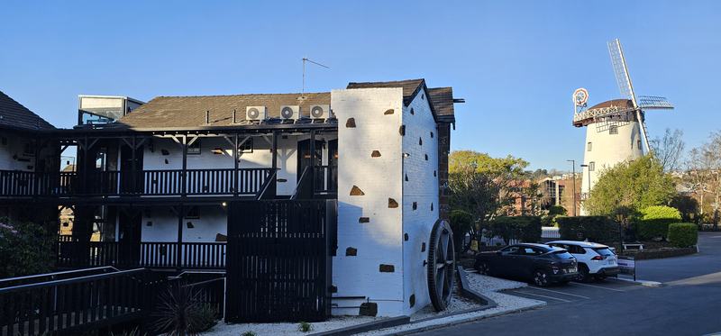 A gorge at the end of the street β The accommodation block in black timber and whitewashed brick, with a large iron