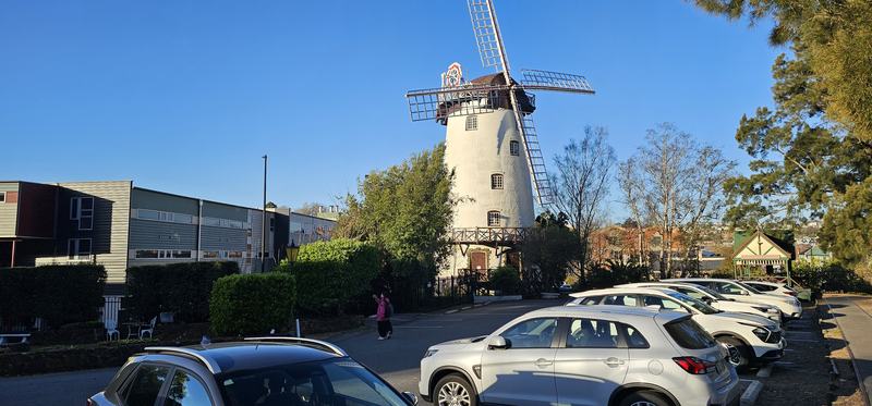 A gorge at the end of the street β The Penny Royal windmill, white tower with full sails, above the hotel car park