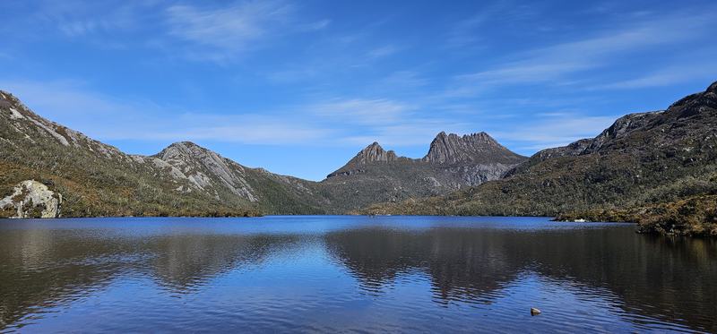 Weindorfer's mountain — Cradle Mountain's jagged profile reflected in Dove Lake under a clear blue sky