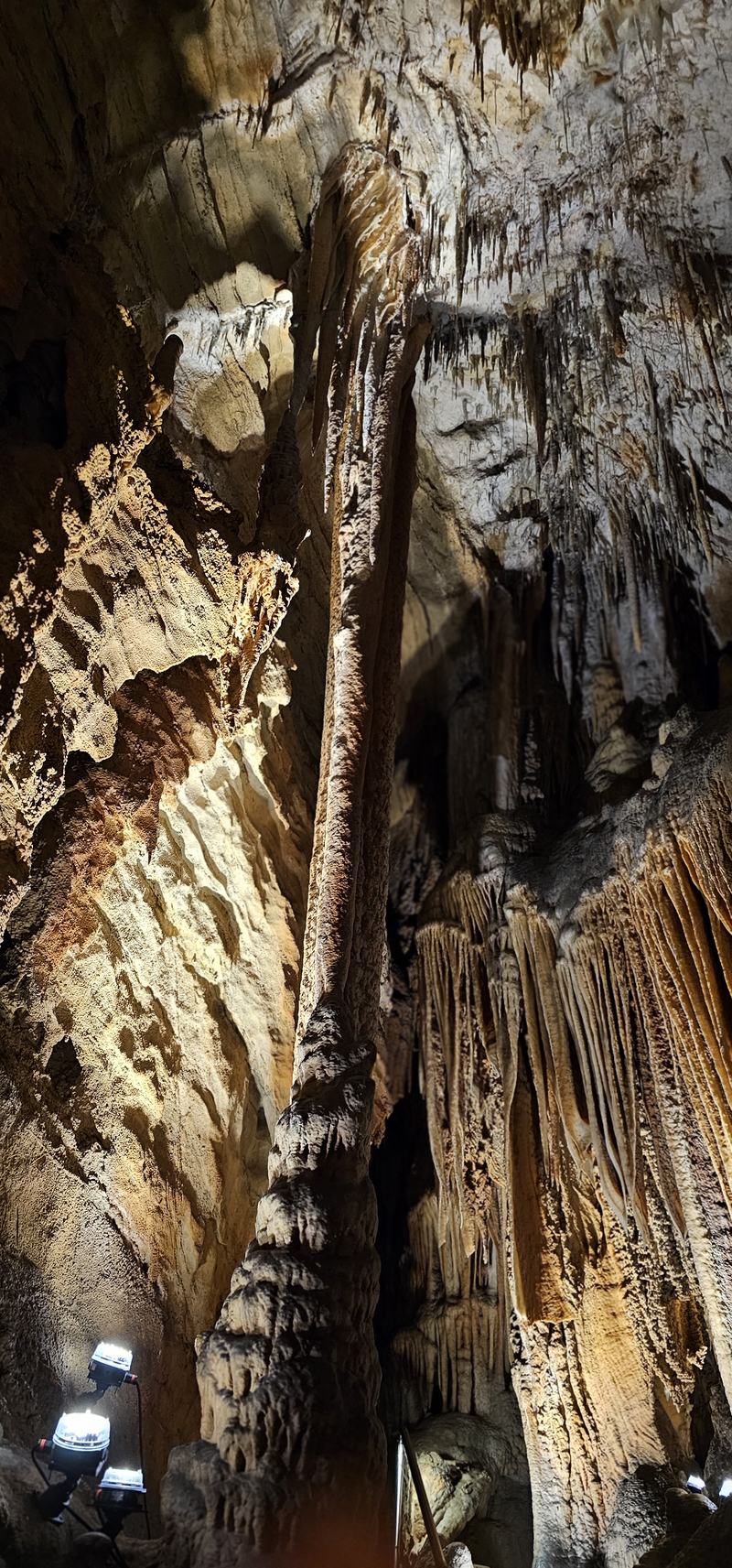 Weindorfer's mountain — A tall stone column rising from the cave floor to the ceiling, lit gold, with cu