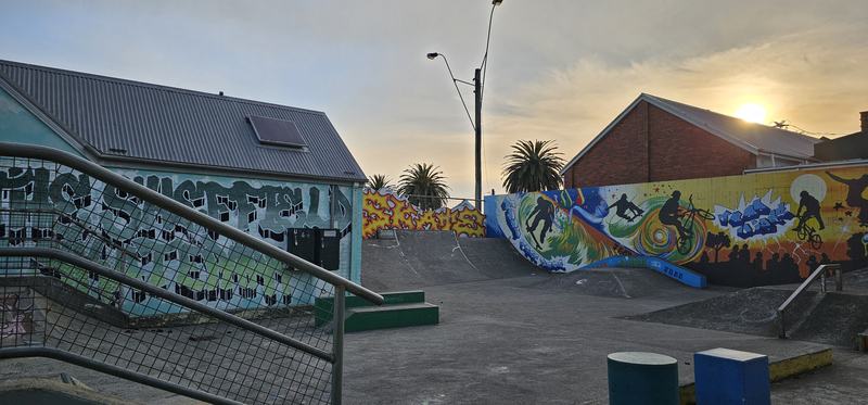 Weindorfer's mountain — A skate park at sunset, its walls and ramps covered in graffiti murals, palm tre