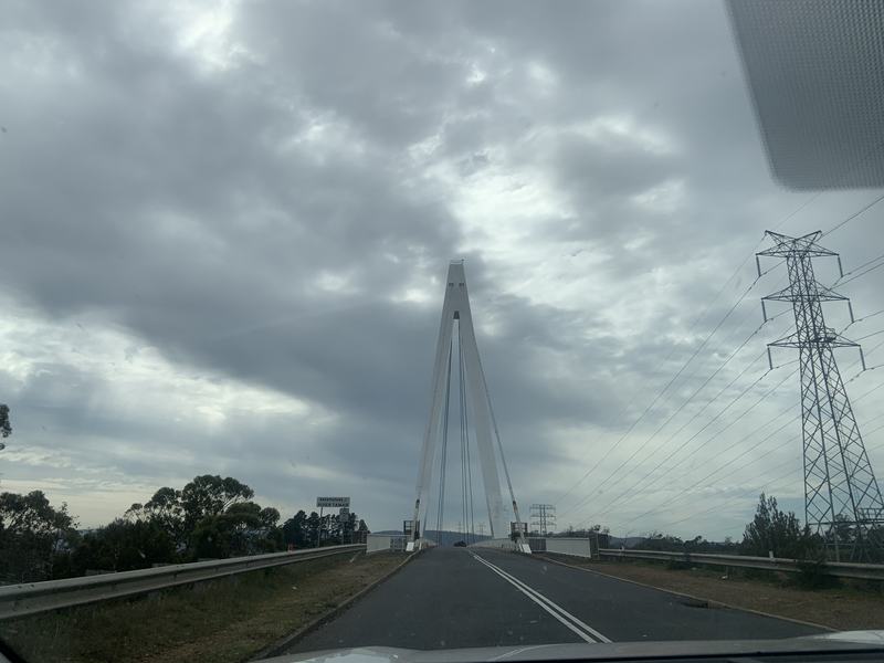 Up the Tamar — Driving onto the Batman Bridge, the A-frame tower straight ahead under grey clou