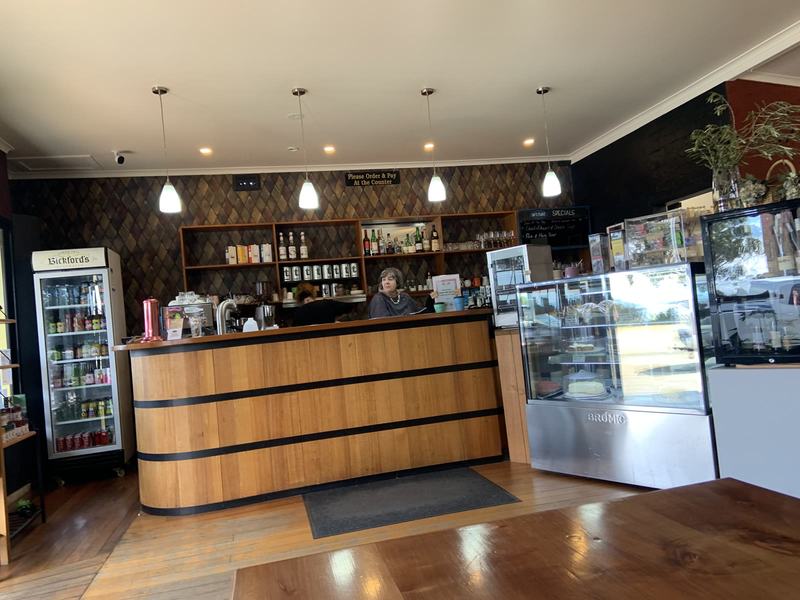 Why it's called Wineglass Bay — The order counter at Artifakt Gallery & Cafe: a curved timber bar banded like a
