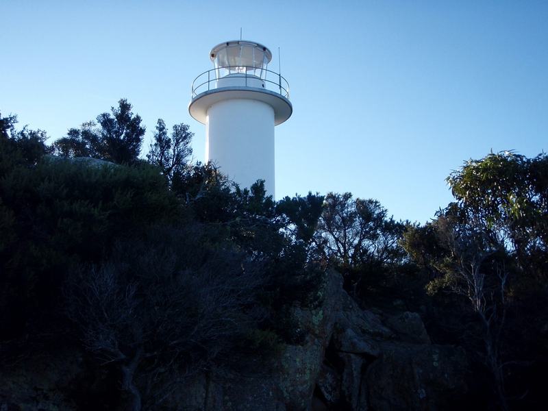 Why it's called Wineglass Bay — Cape Tourville lighthouse, a short white tower on the granite headland, the sea