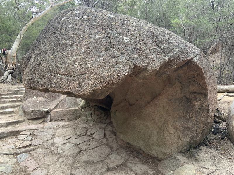 Why it's called Wineglass Bay — A huge granite boulder beside the stone path, hollowed out underneath by the wea