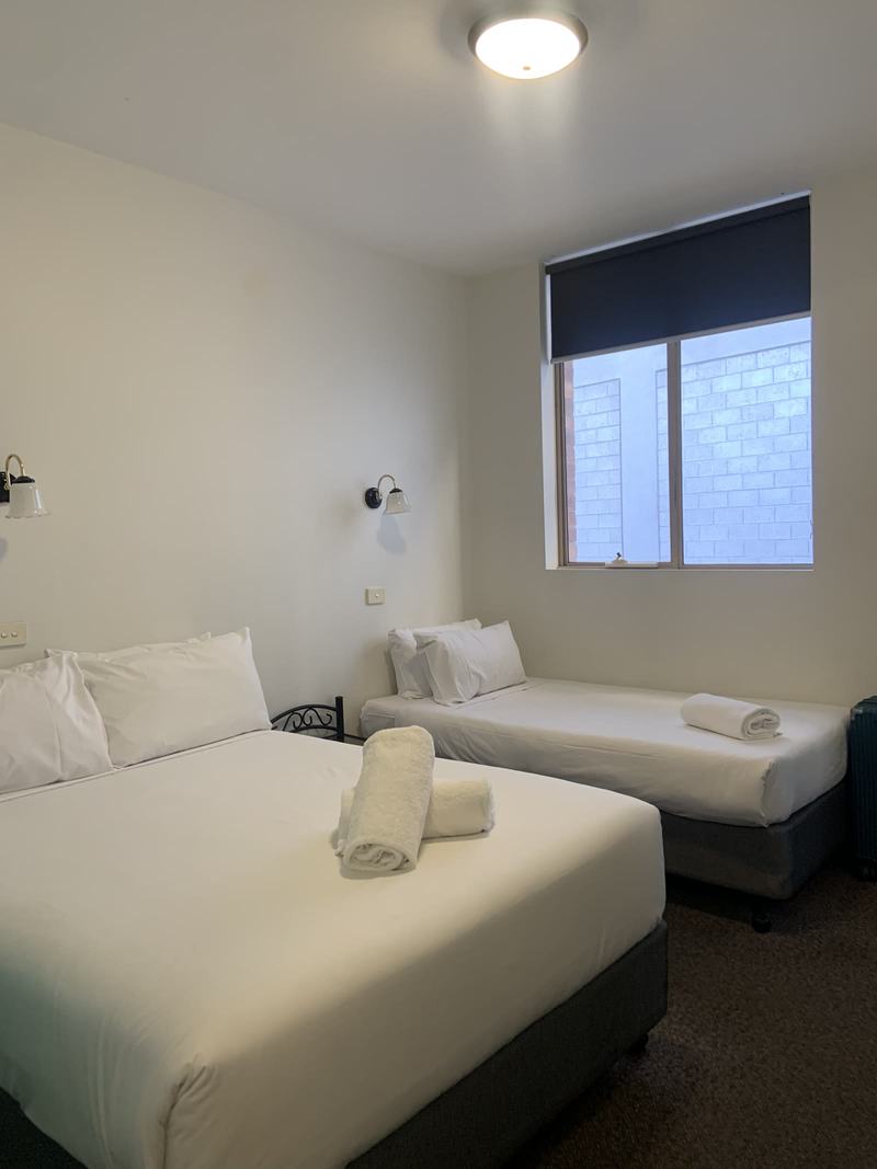Why it's called Wineglass Bay — A YHA Hobart Central room: a double bed and a single bed with a rolled towel on