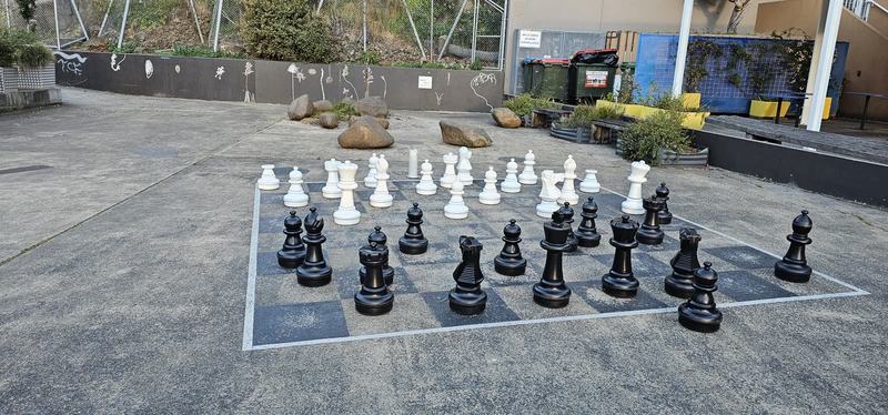 The city that faces south — Giant black and white chess pieces on a board painted on concrete
