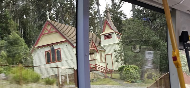A mountain with four names — A small white weatherboard church with red trim and a little bell tower, among t