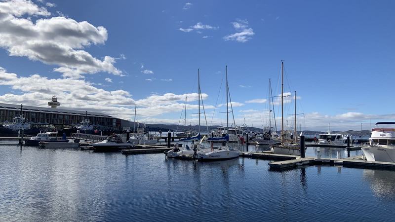 A mountain with four names — Yachts moored in a marina on still water under a blue sky, the long MACq 01 hote