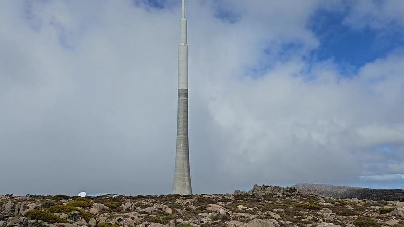 A mountain with four names — Slow pan up the summit transmission tower into cloud (poster)