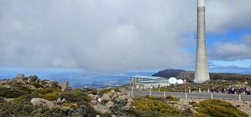 A mountain with four names — The tall concrete summit tower and a low building with satellite dishes, a schoo