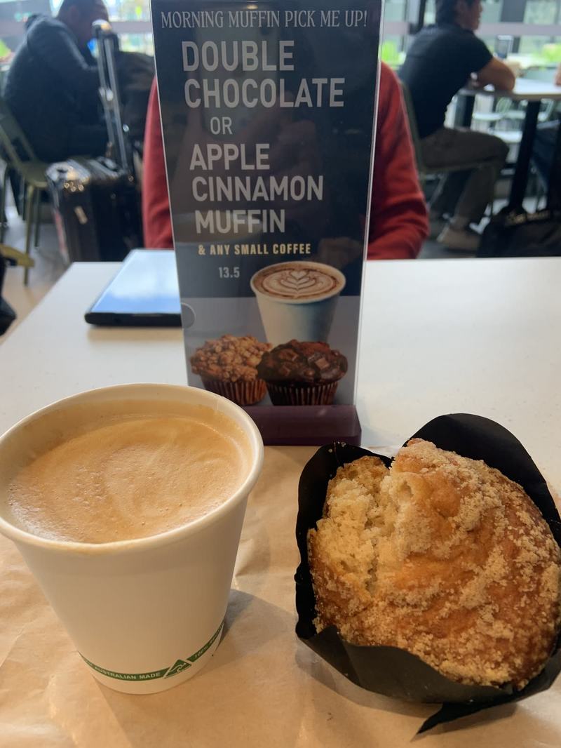 Melbourne anytime — a base, not a checklist — A takeaway coffee with a heart of froth beside a crumb-topped muffin on a café t