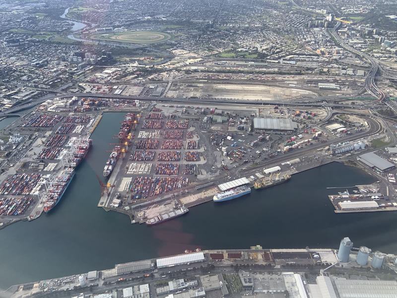 Melbourne anytime — a base, not a checklist — Container ships at a big port on a river, stacks of containers, freeways and a r