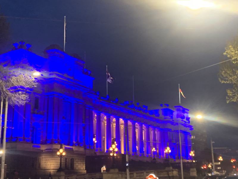 Melbourne anytime — a base, not a checklist — Parliament House lit blue at night, its colonnade and lamp standards glowing, fl