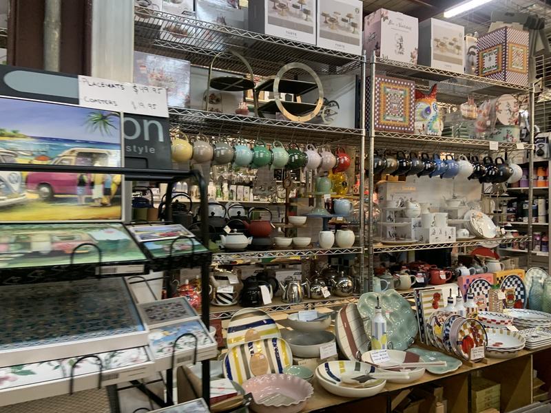 What the gold paid for — Shelves of teapots and mugs and a table of striped and checked plates at a homew